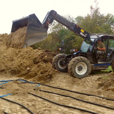 Die Schläuche werden mit Sand bedeckt
