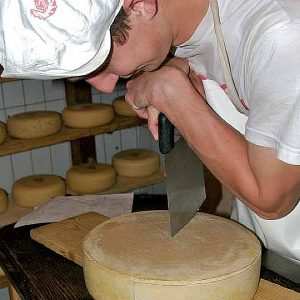 Felix beim Bergkäse-Schneiden